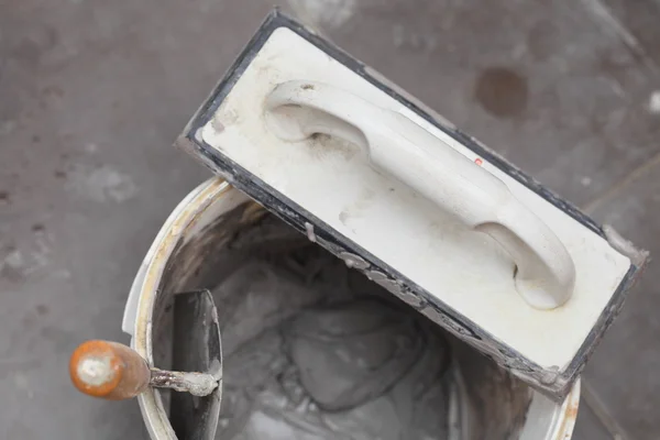 Dirty trowel and bucket on building site. Renovation at home — Stock Photo, Image