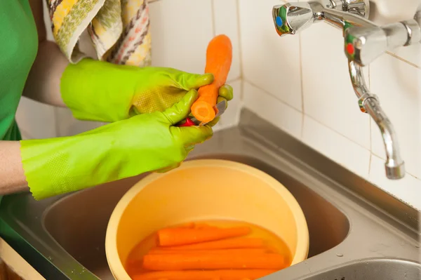 Las manos de mujer cortando zanahorias en la cocina. Nutrición saludable — Foto de Stock