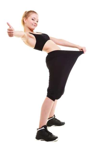 Happy woman showing how much weight she lost, big pants — Stockfoto