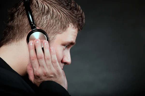 Jeune homme avec écouteurs écoutant de la musique — Photo