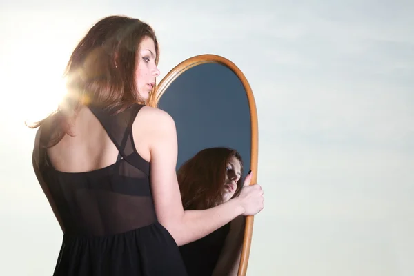 Aynada yansıması, düşünceli kadın bakar — Stok fotoğraf
