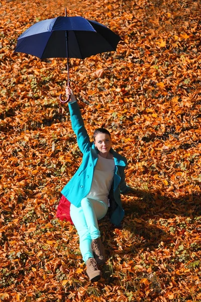 Young girl relaxing with umbrella in autumnal park — Stock Photo, Image