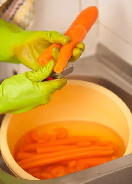 Vrouw handen snijden wortelen in de keuken. Gezonde voeding — Stockfoto