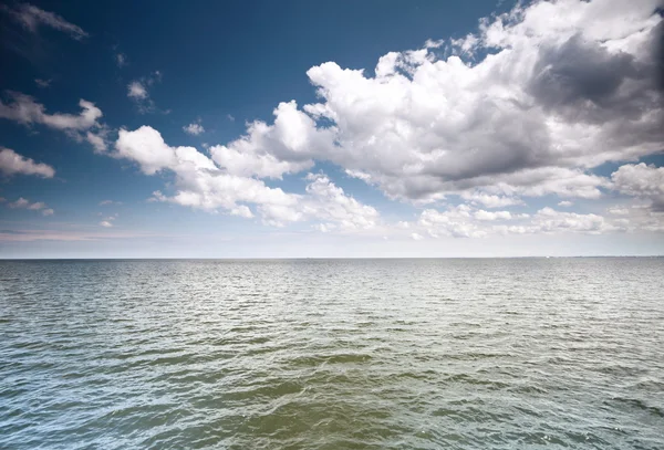 Cielo azul nublado sobre una superficie del mar — Foto de Stock