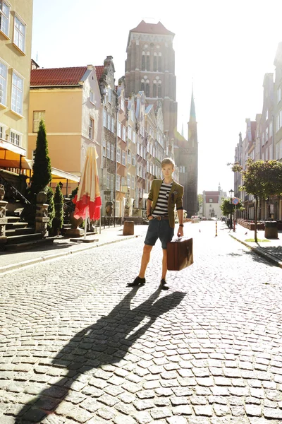 Young handsome man with suitcase on street — Stock Photo, Image