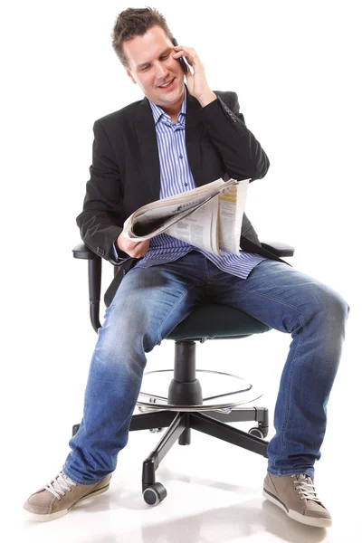 Adam okur gazete telefon ederek - ekonomi haberleri — Stok fotoğraf