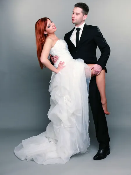Glad gift par brud brudgummen på grå bakgrund — Stockfoto
