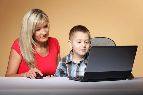 Mãe com filho olhando no laptop — Fotografia de Stock