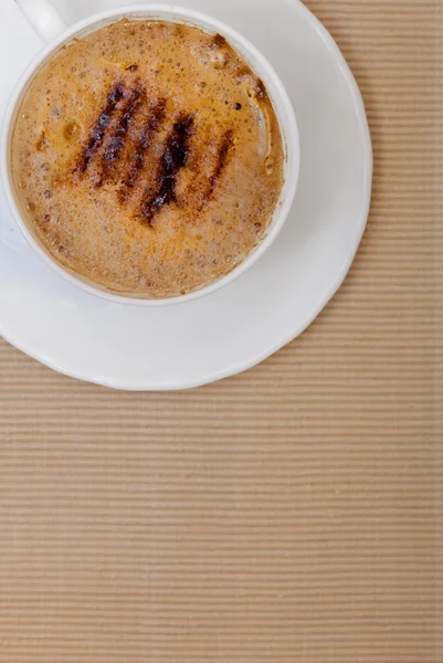 Vit kopp kaffe varm dryck drink med skum på brun bakgrund — Stockfoto