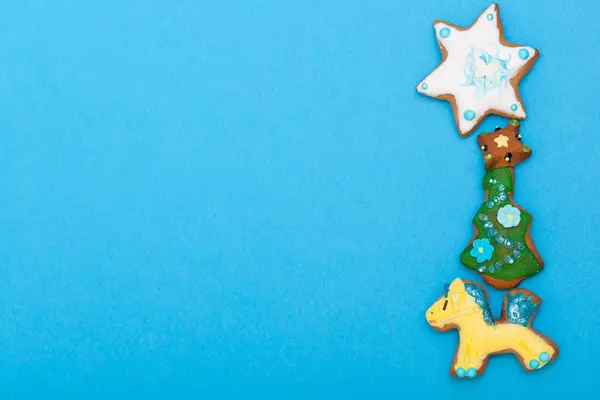 Gingerbread cake pony christmas tree star with icing decoration on blue — Stock Photo, Image