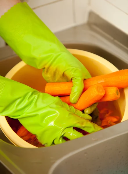 Las manos de mujer cortando zanahorias en la cocina. Nutrición saludable —  Fotos de Stock