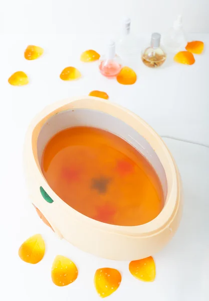 橙色 parrafin 蜡在碗里。在美容院 spa 修指甲. — 图库照片