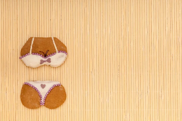 Bikini blanco violeta en forma de galleta de pan de jengibre en estera de bambú —  Fotos de Stock