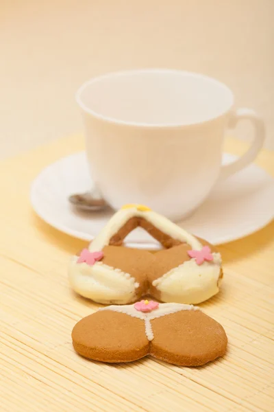 White cup bikini underwear gingerbread cake cookie on bamboo mat — Stock Photo, Image