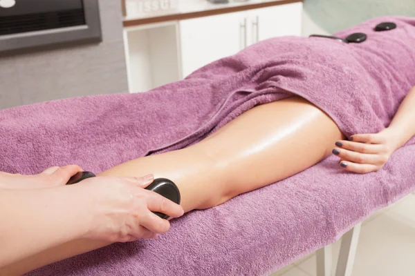 Schönheitssalon. Frau bekommt Thermalbad Hot Stone Beine Massage — Stockfoto