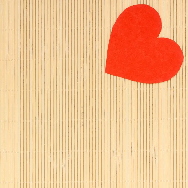 Red heart love symbol on beige bamboo mat valentines day — Stock Photo, Image