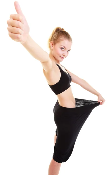 Happy woman showing how much weight she lost, big pants — Stock Photo, Image