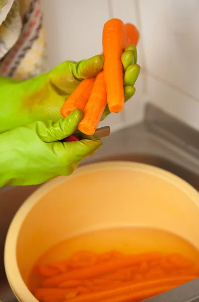 女人手切片胡萝卜在厨房里。健康营养 — 图库照片
