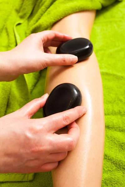 Salão de beleza. Mulher recebendo spa massagem pernas de pedra quente — Fotografia de Stock