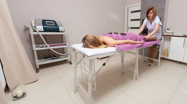 Salón de belleza. Mujer consiguiendo spa caliente piedra terapia masaje —  Fotos de Stock