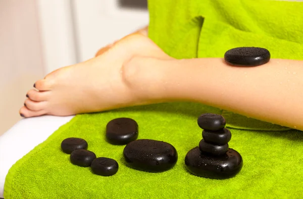 Salão de beleza. Mulher recebendo spa massagem pernas de pedra quente — Fotografia de Stock