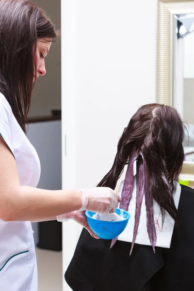 Coiffeur appliquant la couleur client féminin au salon, faire de la teinture capillaire — Photo