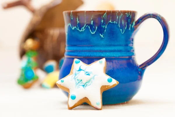 Blue mug and christmas gingerbread cake star icing decoration — Stock Photo, Image
