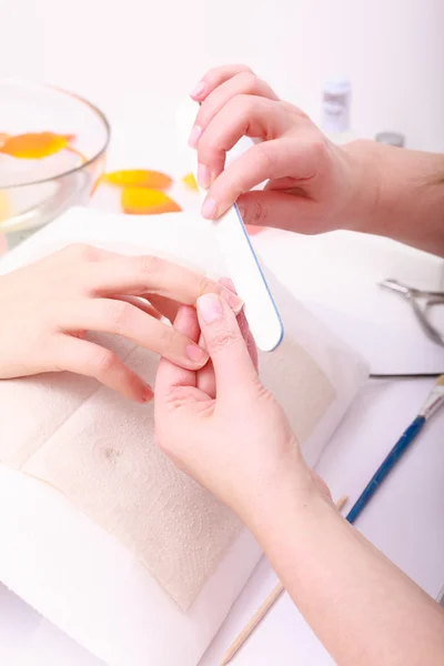 Beautician with file filing nails female client. Woman spa beauty salon — Stock Photo, Image