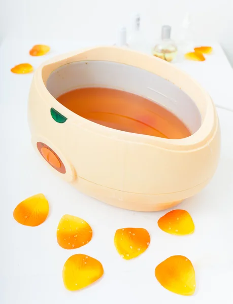 Cera de parrafina naranja en tazón. Manicura en salón de spa de belleza . — Foto de Stock