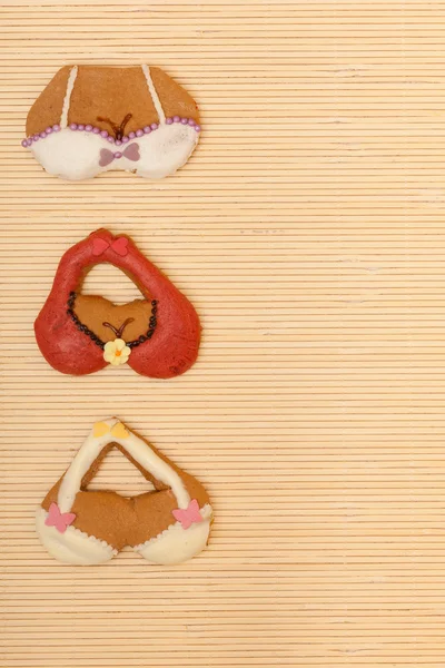 Funny bikini bra shape gingerbread cakes cookies bamboo mat — Stock Photo, Image