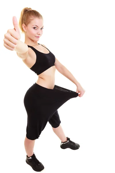 Happy woman showing how much weight she lost, big pants — Stock Photo, Image