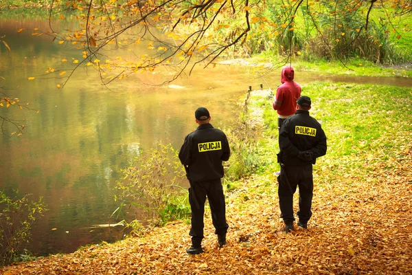 Policjanci sprawdzanie jesienny park rybak. kontroli połowów. — Zdjęcie stockowe