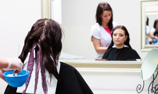 Coiffeur appliquant la couleur client féminin au salon, faire de la teinture capillaire — Photo