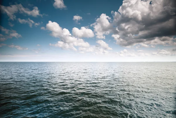 Cielo azul nublado sobre una superficie del mar —  Fotos de Stock