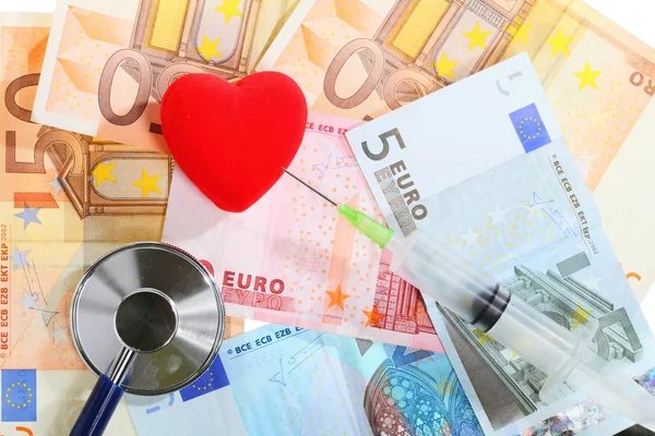 Custo dos cuidados de saúde: estetoscópio coração vermelho em dinheiro do euro — Fotografia de Stock