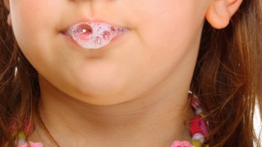 Close up little girl doing fun saliva bubbles clipart