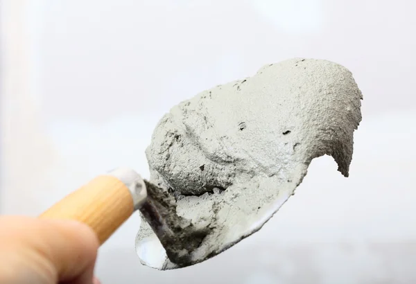 Ruka držící lopaty lžíce s cementovou Maltou — Stock fotografie