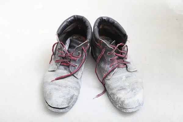 stock image pair of old dirty work boots in building site