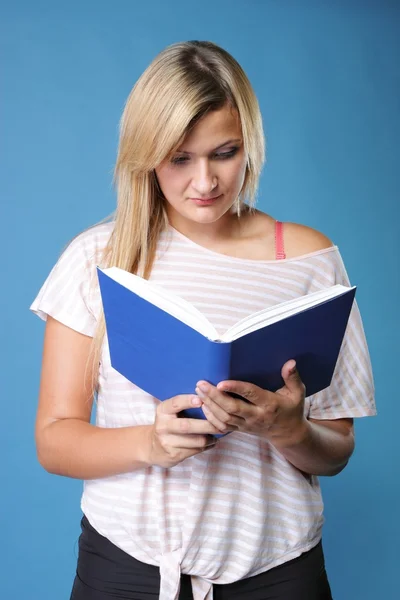 Blonda flickan läsa bok på blå — Stockfoto