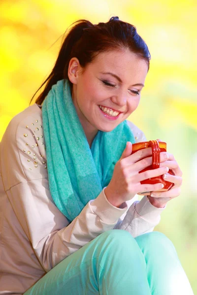 Menina feliz relaxante no parque de outono desfrutando de bebida quente — Fotografia de Stock