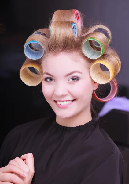 Happy loira menina rolos de encrespadores de cabelo por haidresser no salão de beleza — Fotografia de Stock