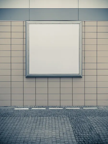 タイル張りの壁に空の空白正方形の白い広告看板 — ストック写真