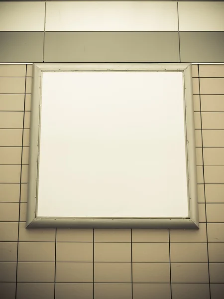 Leere leere quadratische weiße Werbetafel an gekachelter Wand — Stockfoto