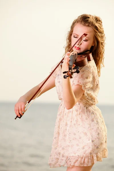 Блондинка со скрипкой на улице — стоковое фото