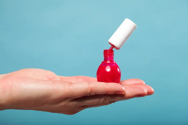 Pedicure manicure red nail polish on female palm — Stock Photo, Image