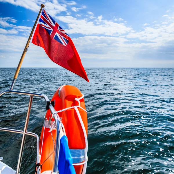 Blue sea. View from deck of yacht sailboat british flag lifebuoy. Travel. — Stock Photo, Image