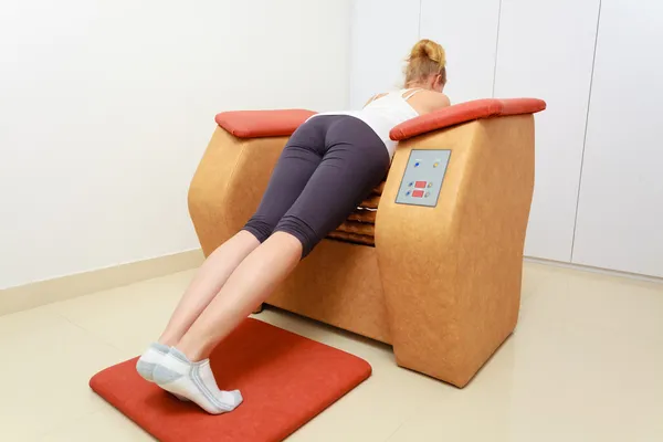 Dziewczyna w Odzież sportowa za pomocą relaks salonu masażu sprzęt spa zdrowy — Zdjęcie stockowe