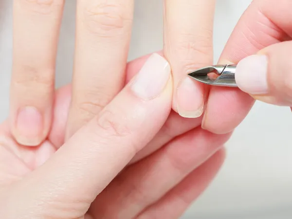 Kosmetikerin trimmt Nagelhaut einer Kundin im Schönheitssalon — Stockfoto