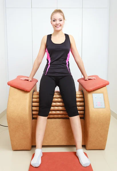 Девушка в спортивной форме с использованием релаксационного массажного оборудования — стоковое фото