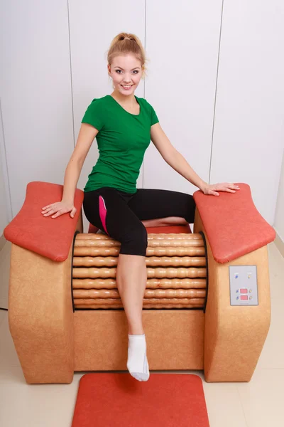 Девушка в спортивной форме с использованием релаксационного массажного оборудования — стоковое фото